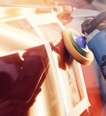 Auto body work technician buffing car